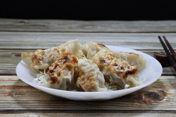 Pile of Gyoza (Japanese fried dumpling) serving on the plate. Famous appetizer menu in Asia restaurant. 