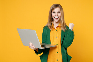 Little blonde pretty cute kid girl 12-13 years old in casual clothes hold laptop pc computer do...