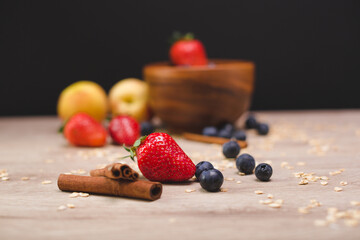 delicious berries and cereals on the background of porridge in a wooden bowl. Delicious fruit breakfast. High quality photo