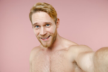 Fototapeta premium Close up of smiling bearded naked young man 20s years old perfect skin doing selfie shot on mobile phone isolated on pink background studio portrait. Skin care healthcare cosmetic procedures concept.