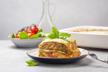 Green lasagna - Lasagne alla bolognese with spinach in the dough, ragu - meat sauce, bechamel and parmesan cheese. Italian food.  Horizontal image.
