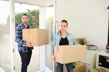 happy young couple moving carboard boxes and furnitures during move into a new home flat apartment