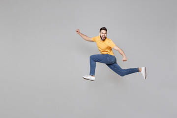 Full length of young bearded sport active student hurrying man 20s wearing yellow basic t-shirt...