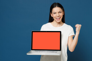 Young smiling copywriter freelancer latin woman 20s in white t-shirt hold laptop pc computer blank...