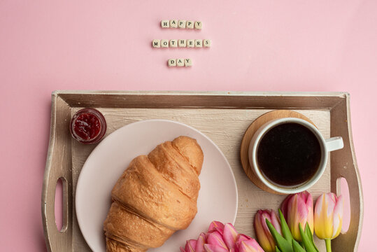 Espresso, croissants and flowers on a tray. Romantic breakfast for mother's day. - Powered by Adobe