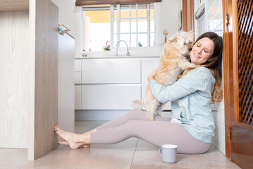Young woman embraces her dog at home
