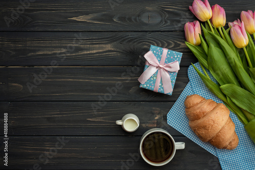 Mother's Day greeting message with tulips, gift and coffee on wooden background. Background for International Mother Day.