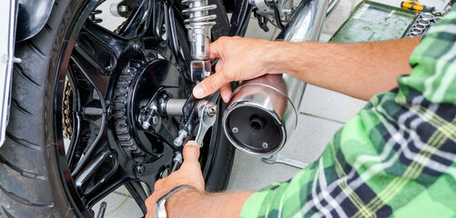 Fototapeta na wymiar Motorrad Reparatur - Mechaniker repariert Motorrad in Werkstatt