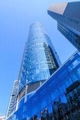 Skyscrapers and high-rise buildings in the financial and business district of Frankfurt. Looking up along the window facade in the city center. Blue sky in sunny day. Reflections in the glass facade