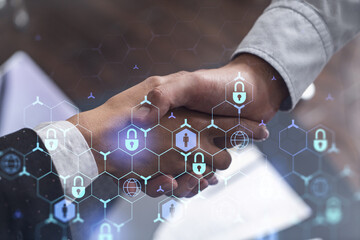 Handshake of two businesspeople who are negotiated the project to protect cyber security of...