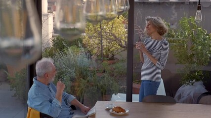 Senior couple talking and drinking coffee on rooftop terrace - Powered by Adobe