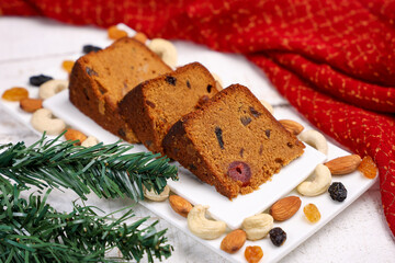 Indian Christmas celebration homemade Christmas plum cake cut into pieces for serving India Kerala Sri Lanka Fruitcake made of dried fruit, nuts, spices , rum for New Year party, Easter, Christmas Eve