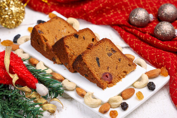 Indian Christmas celebration homemade Christmas plum cake cut into pieces for serving India Kerala Sri Lanka Fruitcake made of dried fruit, nuts, spices , rum for New Year party, Easter, Christmas Eve