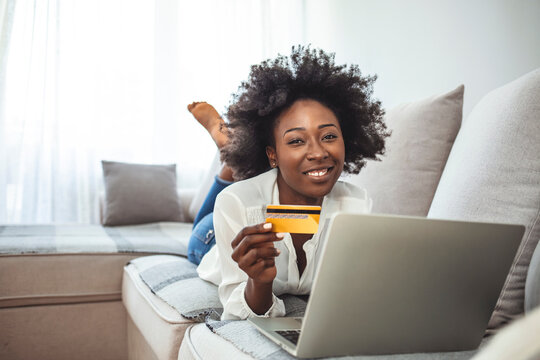 Picture showing pretty woman shopping online with credit card. Woman holding credit card and using laptop. Online shopping concept. Shot of an attractive young woman making payments online