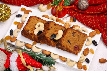 Indian Christmas celebration homemade Christmas plum cake cut into pieces for serving India Kerala Sri Lanka Fruitcake made of dried fruit, nuts, spices , rum for New Year party, Easter, Christmas Eve