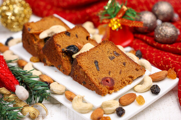 Fototapeta na wymiar Indian Christmas celebration homemade Christmas plum cake cut into pieces for serving India Kerala Sri Lanka Fruitcake made of dried fruit, nuts, spices , rum for New Year party, Easter, Christmas Eve