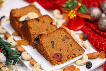 Indian Christmas celebration homemade Christmas plum cake cut into pieces for serving India Kerala Sri Lanka Fruitcake made of dried fruit, nuts, spices , rum for New Year party, Easter, Christmas Eve