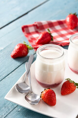 Panna cotta dessert with strawberry on blue wooden table