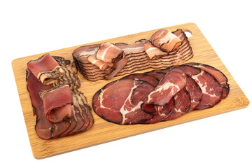 Assorted chopped pork brisket, neck and prosciutto on a wooden cutting board. Pork delicacies on a cutting board over white background. Copy space.