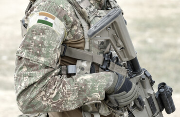 Soldier with assault rifle and flag of India on military uniform. Collage.