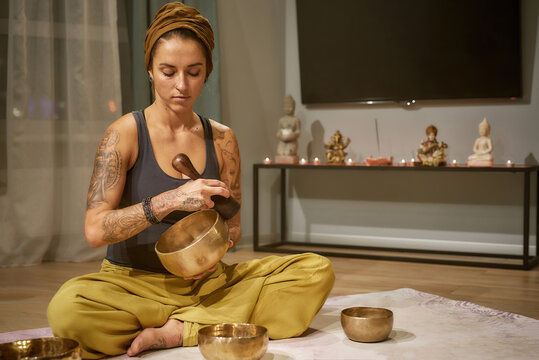 Young Caucasian Woman Using Tibetan Singing Bowl