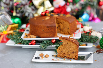 Obraz na płótnie Canvas Indian Christmas celebration serving homemade Christmas plum cake India Kerala. Fruitcake made of dried fruit, nuts, spices , rum for New Year party, Easter, Christmas Eve