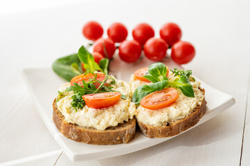 Fototapeta na wymiar egg cheese ham dip, spread on open finger food sandwich with salad, tomato vegetables 