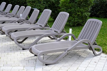 a row of grey sun loungers for sunbathing