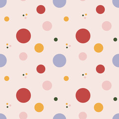 Vector seamless pattern with colored circles in different sizes on light pink background.Bright design with polka dots for fabrics, textile, clothes, kids room, wrapping paper and other surfaces