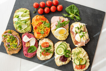 selection board of open sandwiches dips, spreads, cold cut meat, cheese, egg and salad 