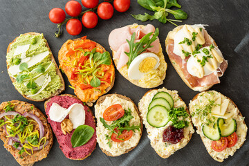 selection board of open sandwiches dips, spreads, cold cut meat, cheese, egg and salad 