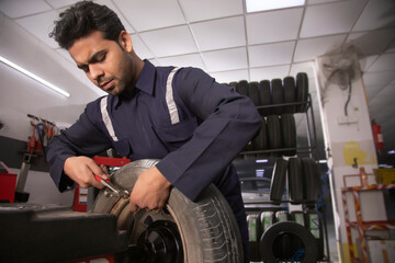 Fototapeta na wymiar Technician doing wheel balancing of a tyre at a tyre shop 