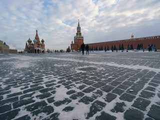 Photography of Moscow downtown, Red Square at winter day. Bright Saint Basil's Cathedral (Cathedral of Vasily the Blessed), Spasskaya Tower.  Blue sky had been covered by white clouds