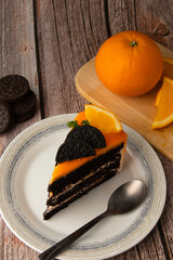 Orange chocolate cake with orange fruit commuter and spoon on a plate.