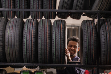 Fototapeta na wymiar Mechanic selecting tyres in car service centre 