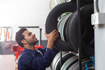 Mechanic selecting tyres at a tyre shop	