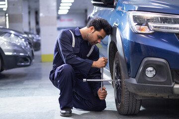 Mechanic changing car tire, during repair and maintenance of a car at a workshop  © IndiaPix