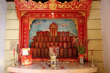 Hoi An, Vietnam, March 8, 2021: Altar decorated with red and gold colors of a Taoist Temple in Hoi An, Vietnam