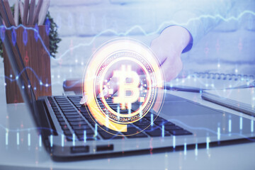 Double exposure of woman hands typing on computer and crypto market theme hologram drawing....