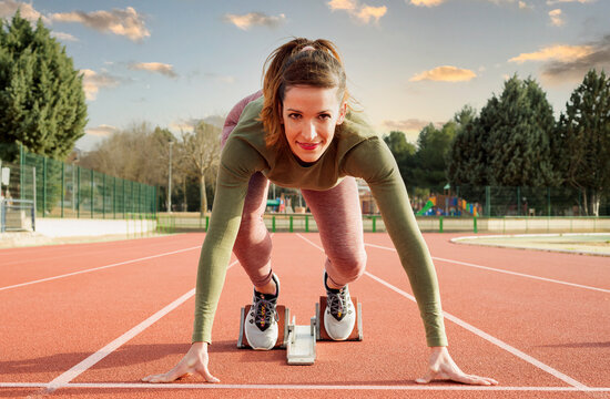 Young woman in starting position ready for running. 