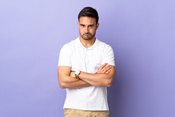 Young handsome man isolated on purple background with unhappy expression