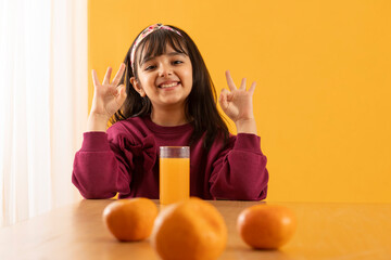 A YOUNG GIRL EXPRESSING HAPPINESS OVER DRINKING FRESH FRUIT JUICE	