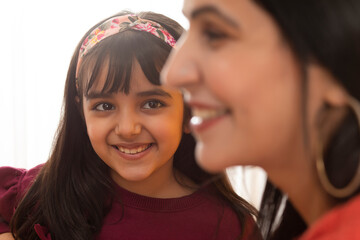 A HAPPY DAUGHTER LOOKING AT MOTHER 	