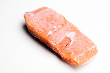 Slice of salmon against isolated white background closeup