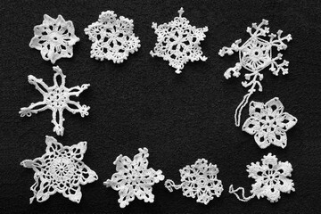 Knitting. Decoration in the form of snowflakes in various combinations on a black background