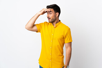 Young handsome man over isolated background doing surprise gesture while looking to the side