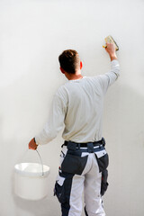 craftsman prime coating a white facade before painting