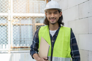 Portrait young asian inspector worker wearing safety helmet and checklist clipboard