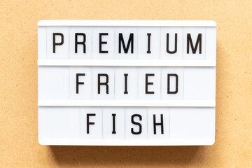 Lightbox with word premium fried fish on wood background