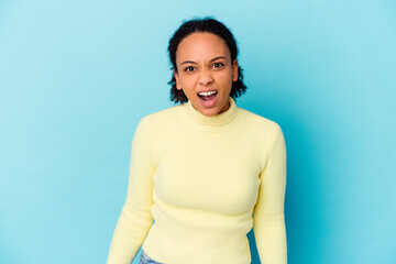 Young african american mixed race woman isolated shouting very angry, rage concept, frustrated.